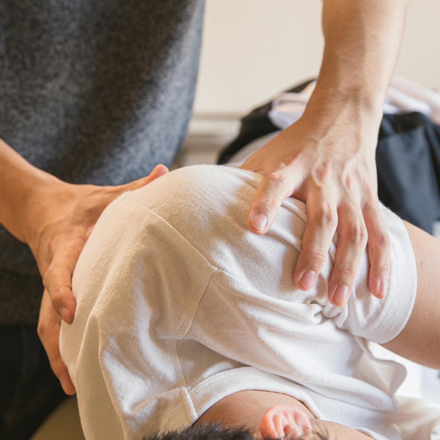 fizjoterapeuta robiący masaż barku pacjentowi w gabinecie rehabilitacyjnym