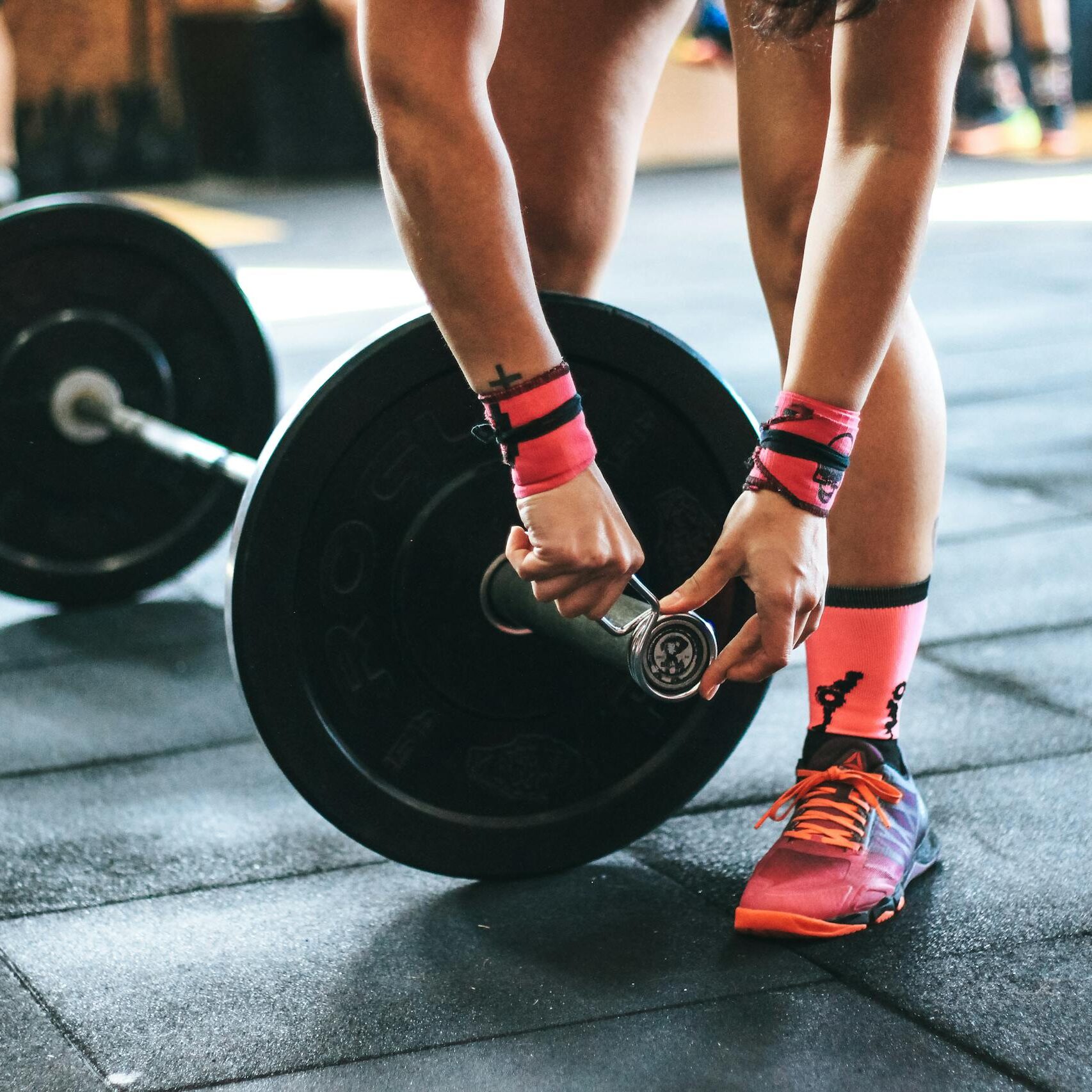 Person Holding Black Barbell